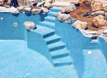 Alternative view of swimming pool with built-in rock feature, created by Almeria Builders